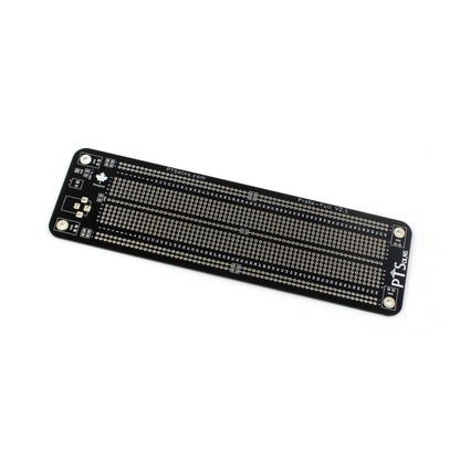 PTSolns Proto-Full prototyping perf board with silkscreen printing on both sides showing dashed white lines indicating electrical connections, separate ground and negative rails, two power input methods (screw terminal and female power jack), four M3 mounting holes for grounding or stacking, multiple configurable power rails, and a central rail that can be connected to ground.